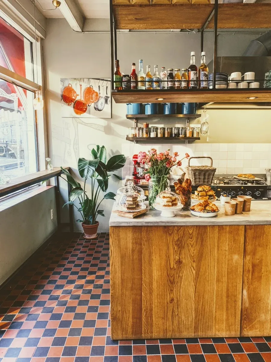Het interieur van Soep-er, met vers gebak en bloemen op de toonbank